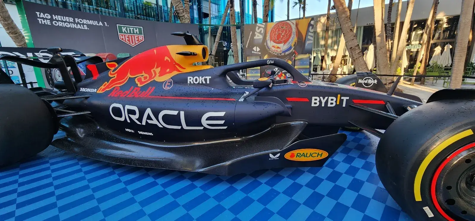 Side profile of the Formula 1 show car on the checkered deck, Kith Heuer logo wall and TAG Heuer Formula 1 header behind
