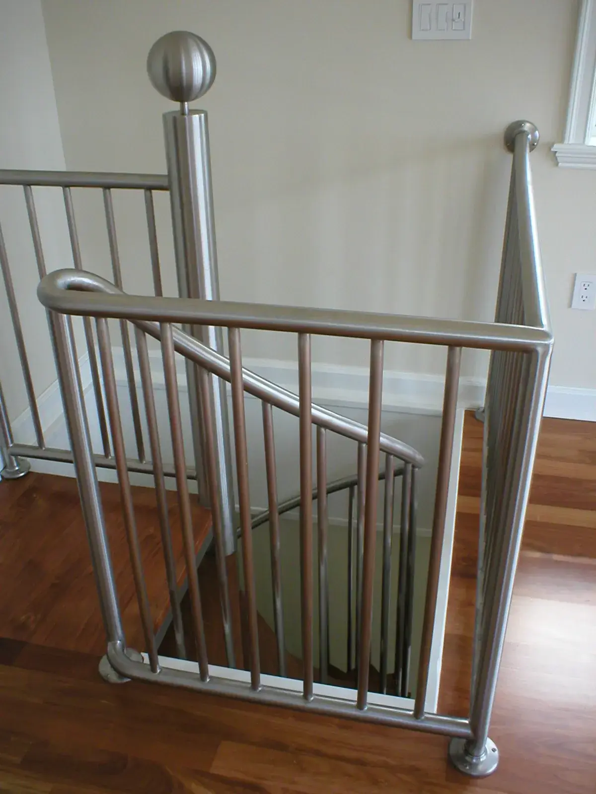 Stainless steel spiral-stair guardrail with ball finial on hardwood