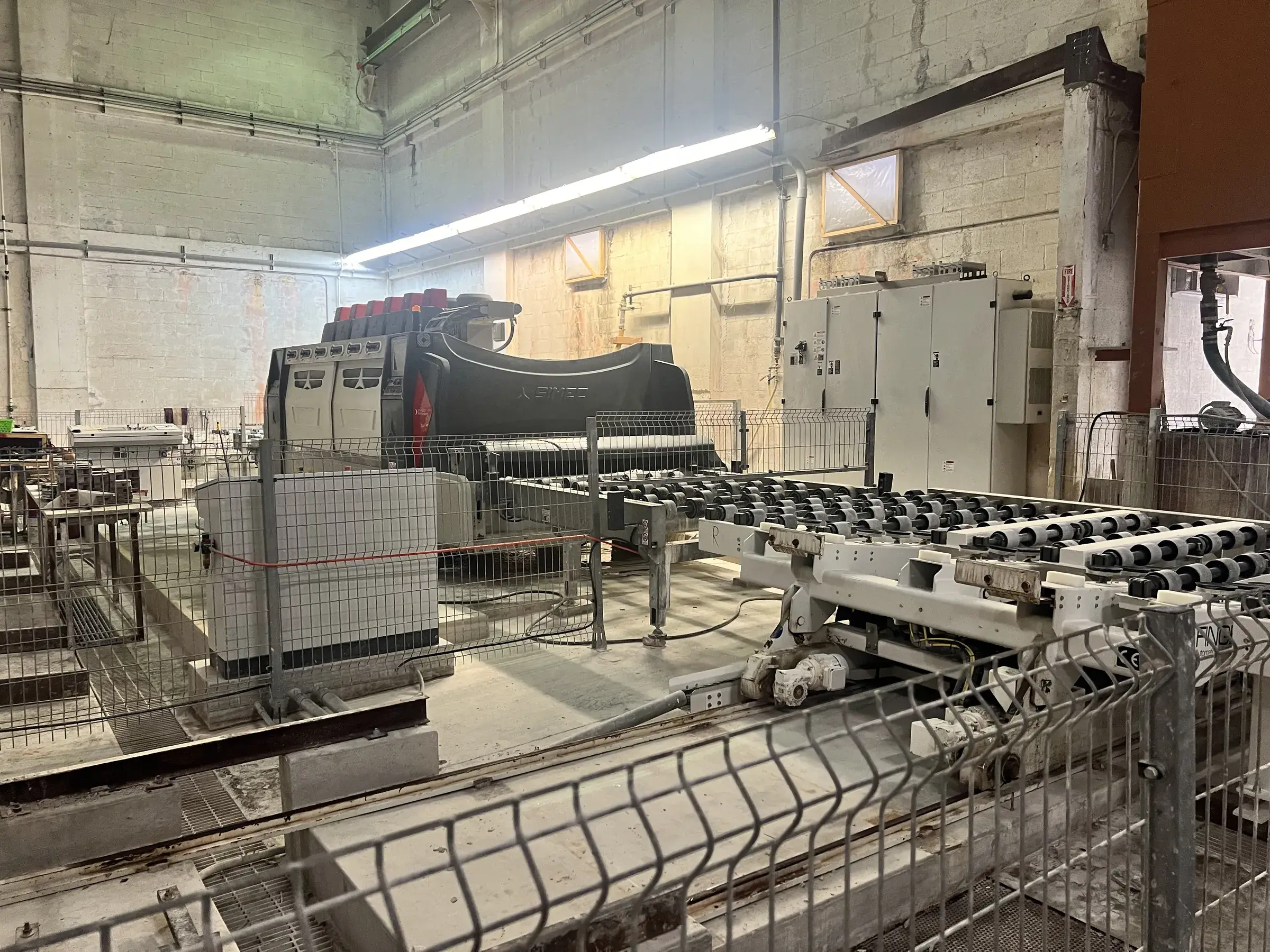 SIMEC polishing line with roller conveyor and safety fencing installed on the raised pads