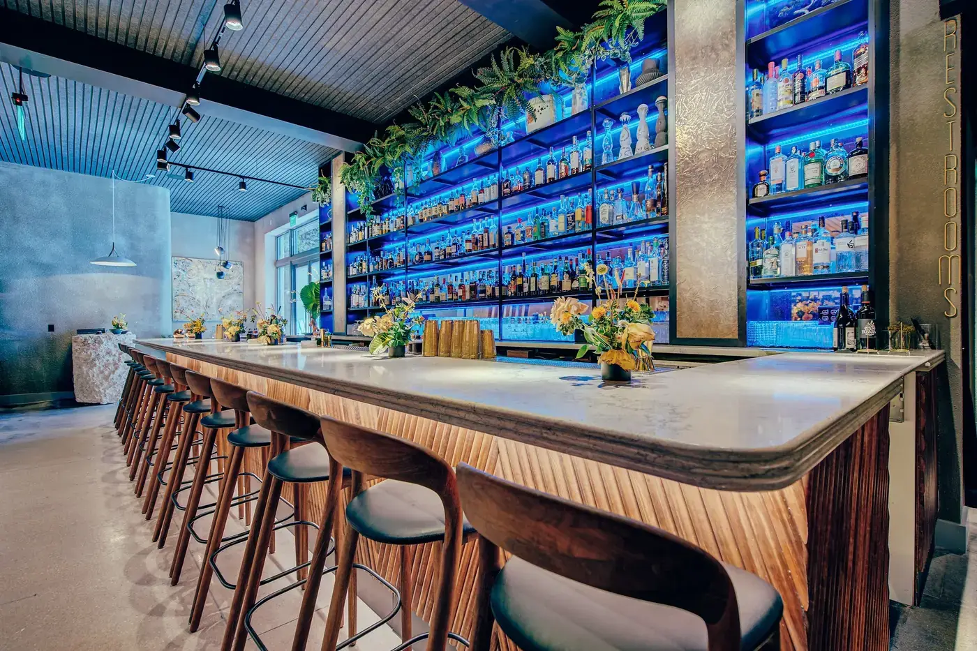 Long marble bar under the illuminated back bar