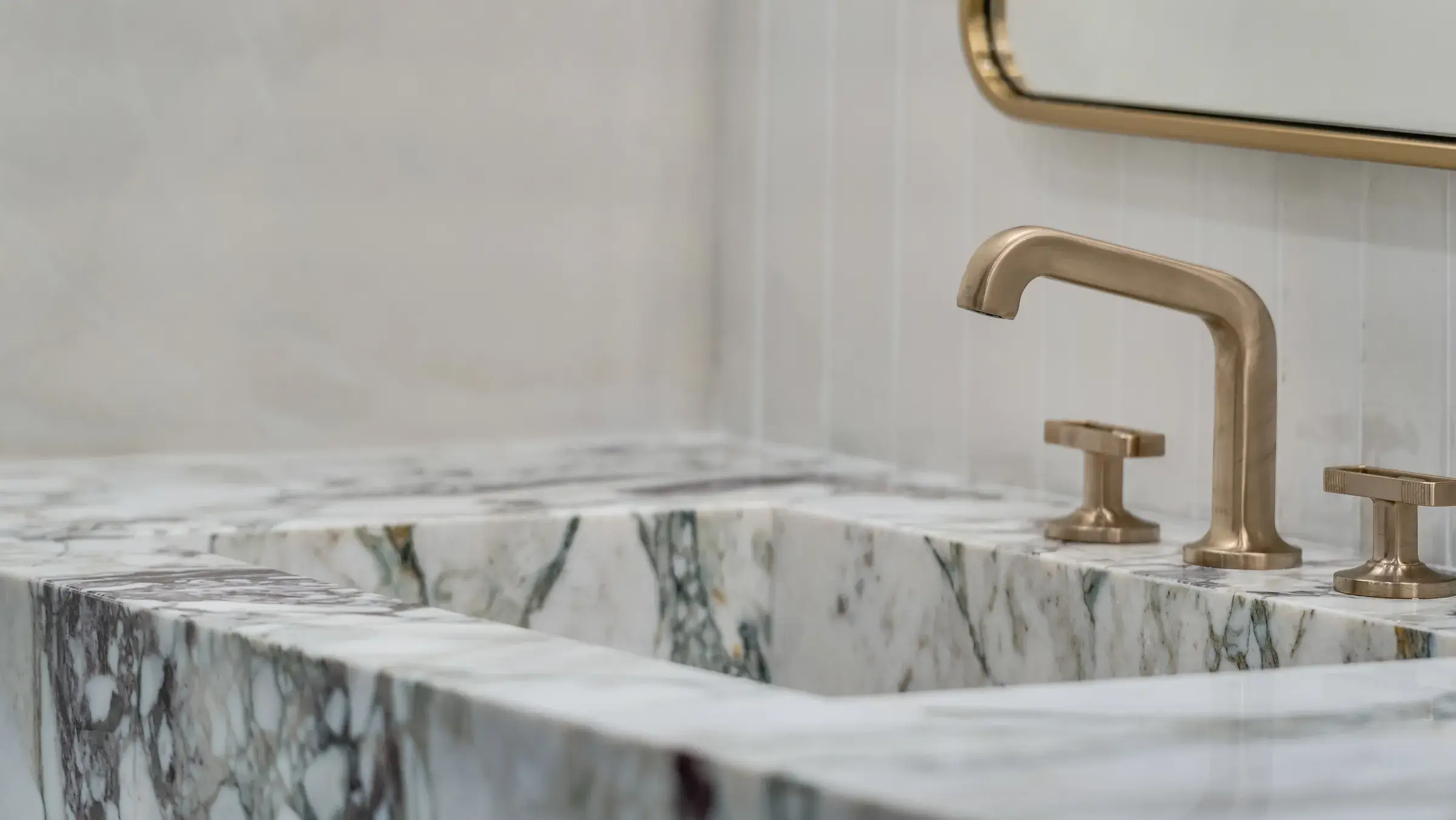 Brass faucet on the carved marble sink basin