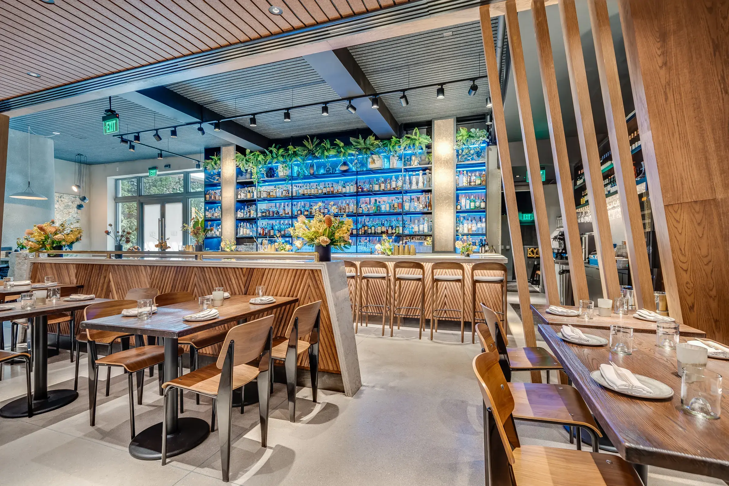 Fin screens, booths, and the bar under the scenic ceiling
