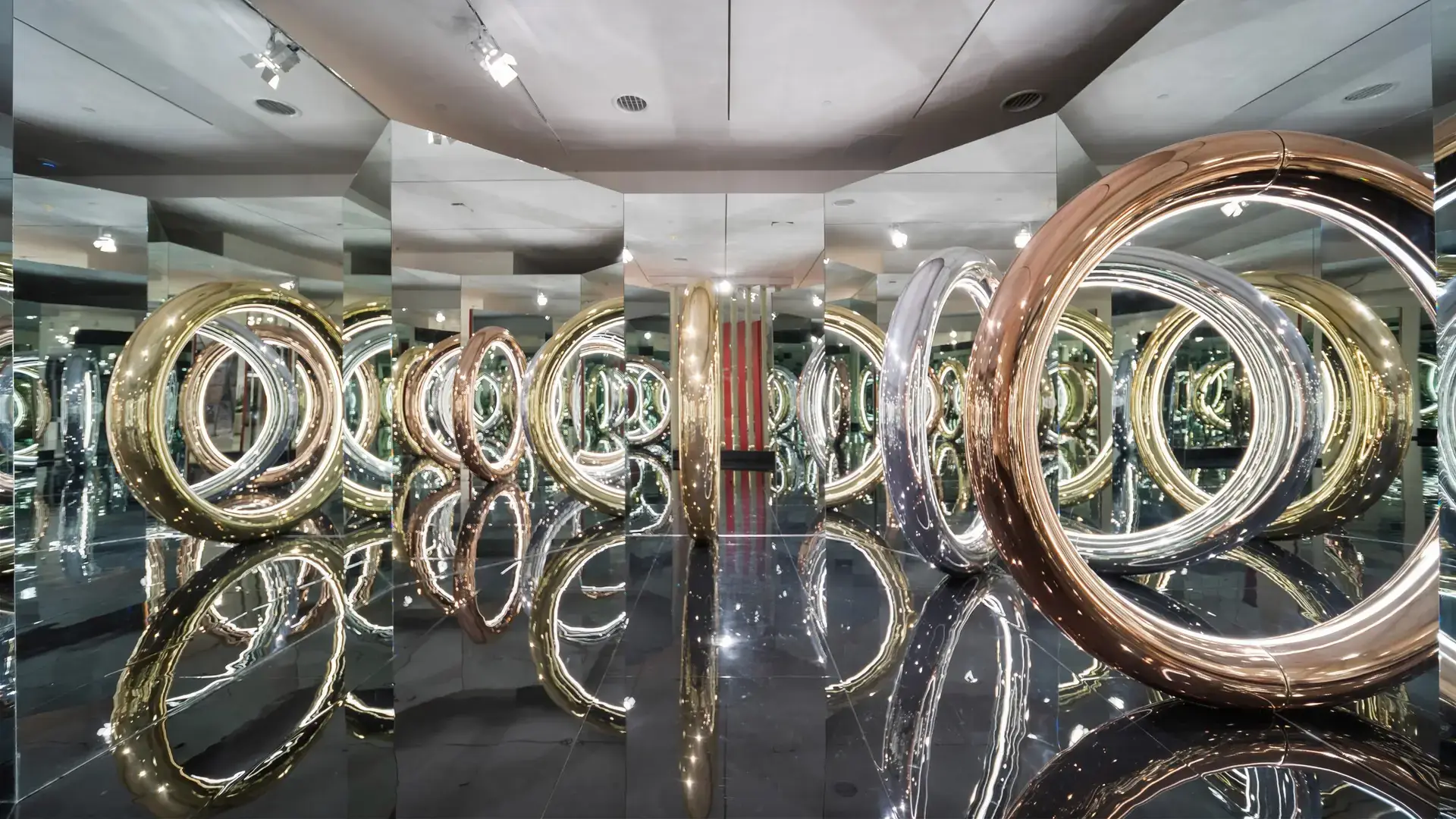 Cartier Trinity 100 installation in the Miami Design District: mirrored room filled with oversized gold, rose, and white gold Trinity rings