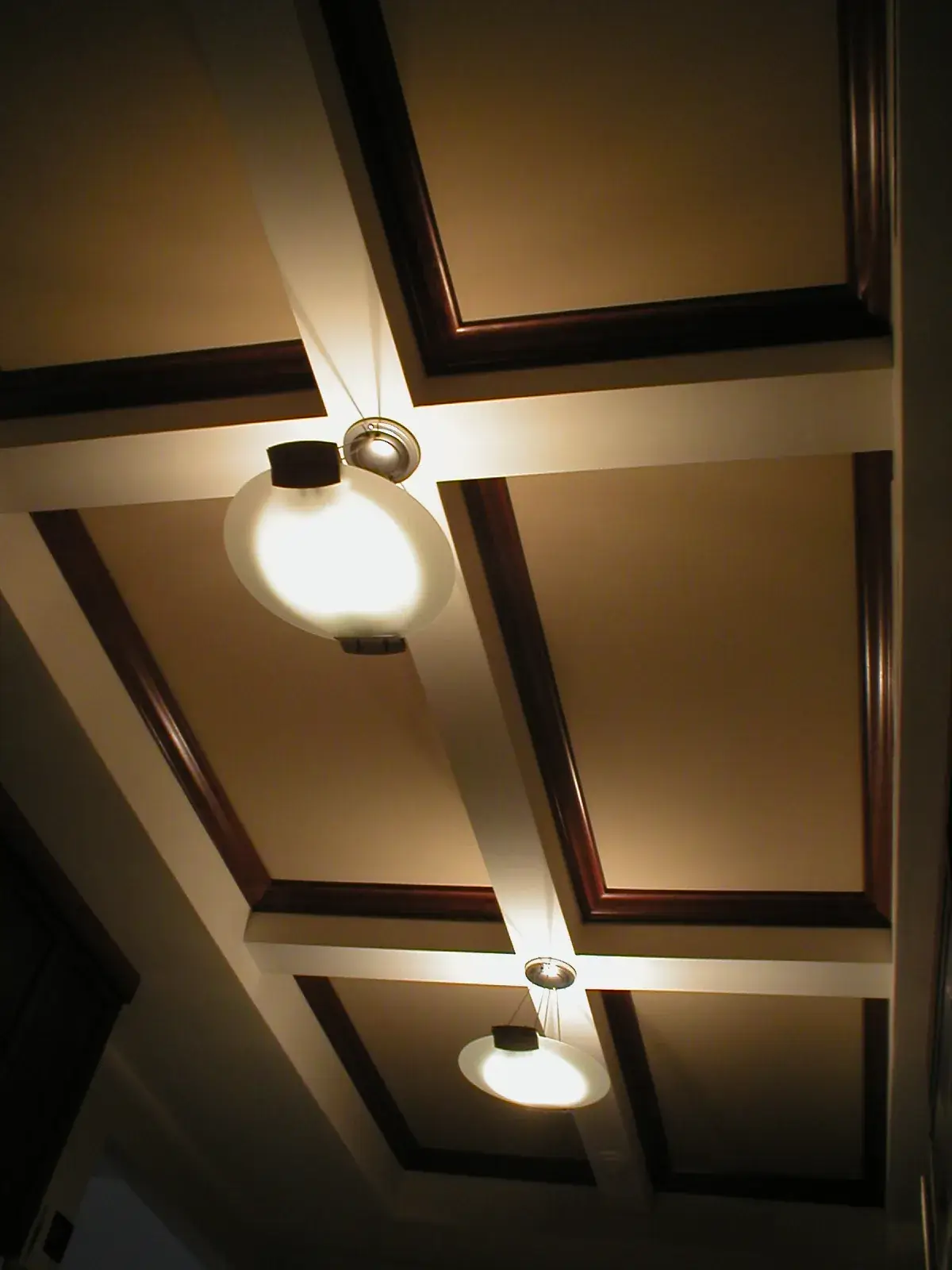 Coffered ceiling with dark wood trim and two pendant lights