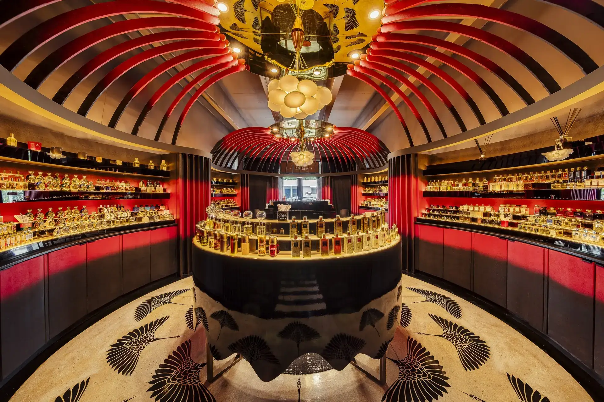 Osme Perfumery flagship with a red ribbed dome, circular display, and curved shelving