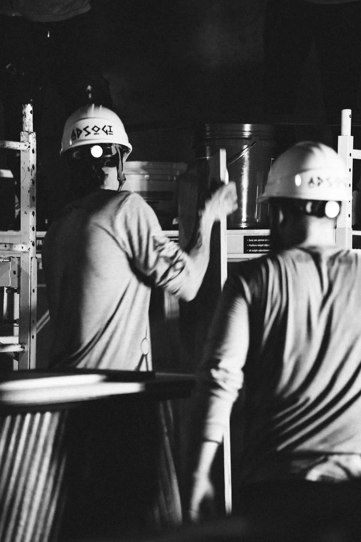 Two APSOGI crew members in branded hard hats on a job site